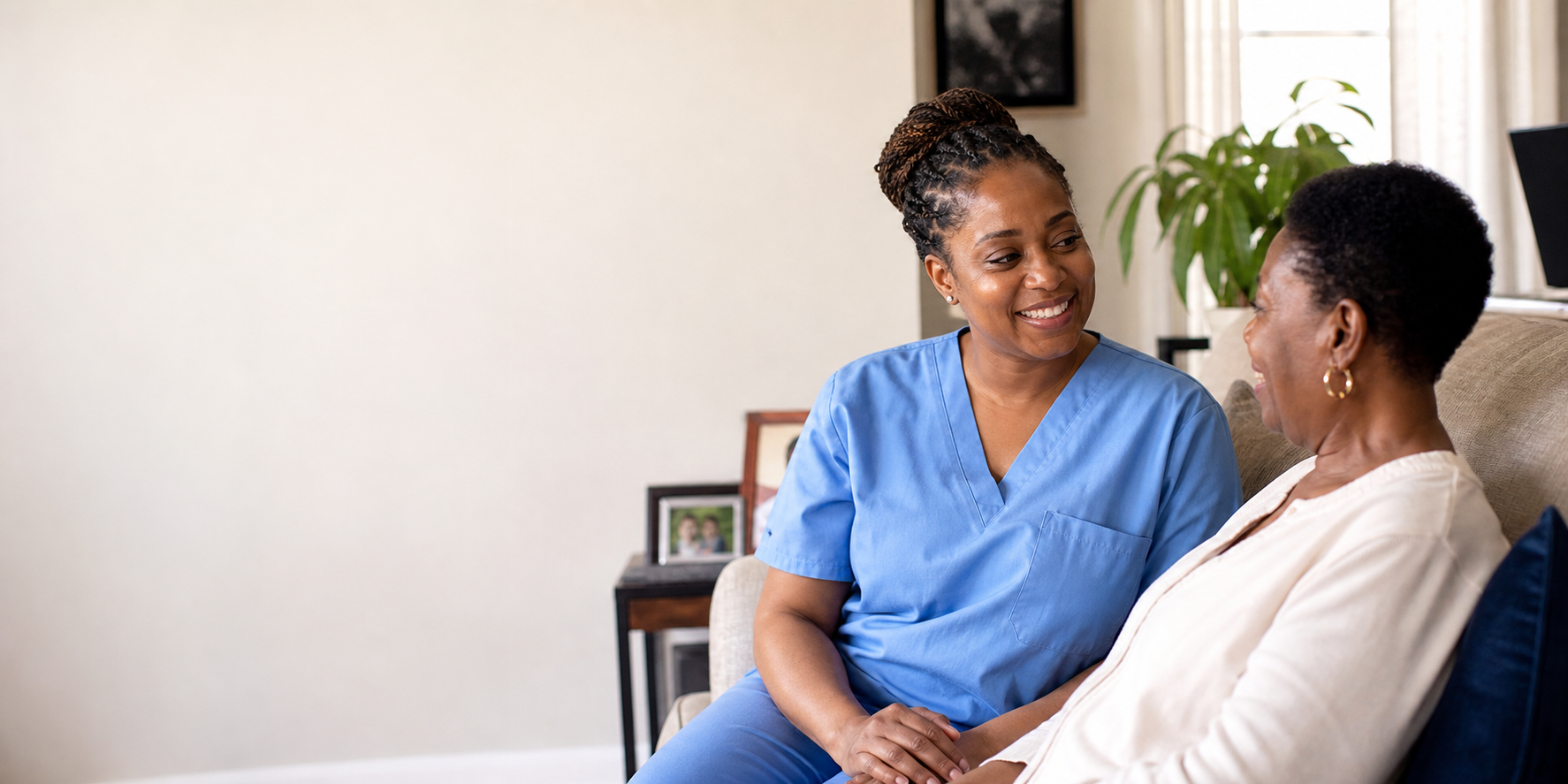 A home health nurse talking warmly with an older client at home